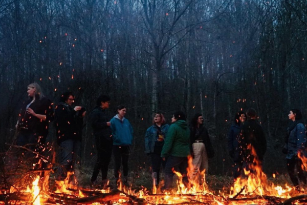 Image of field school students standing behind a fire in the woods
