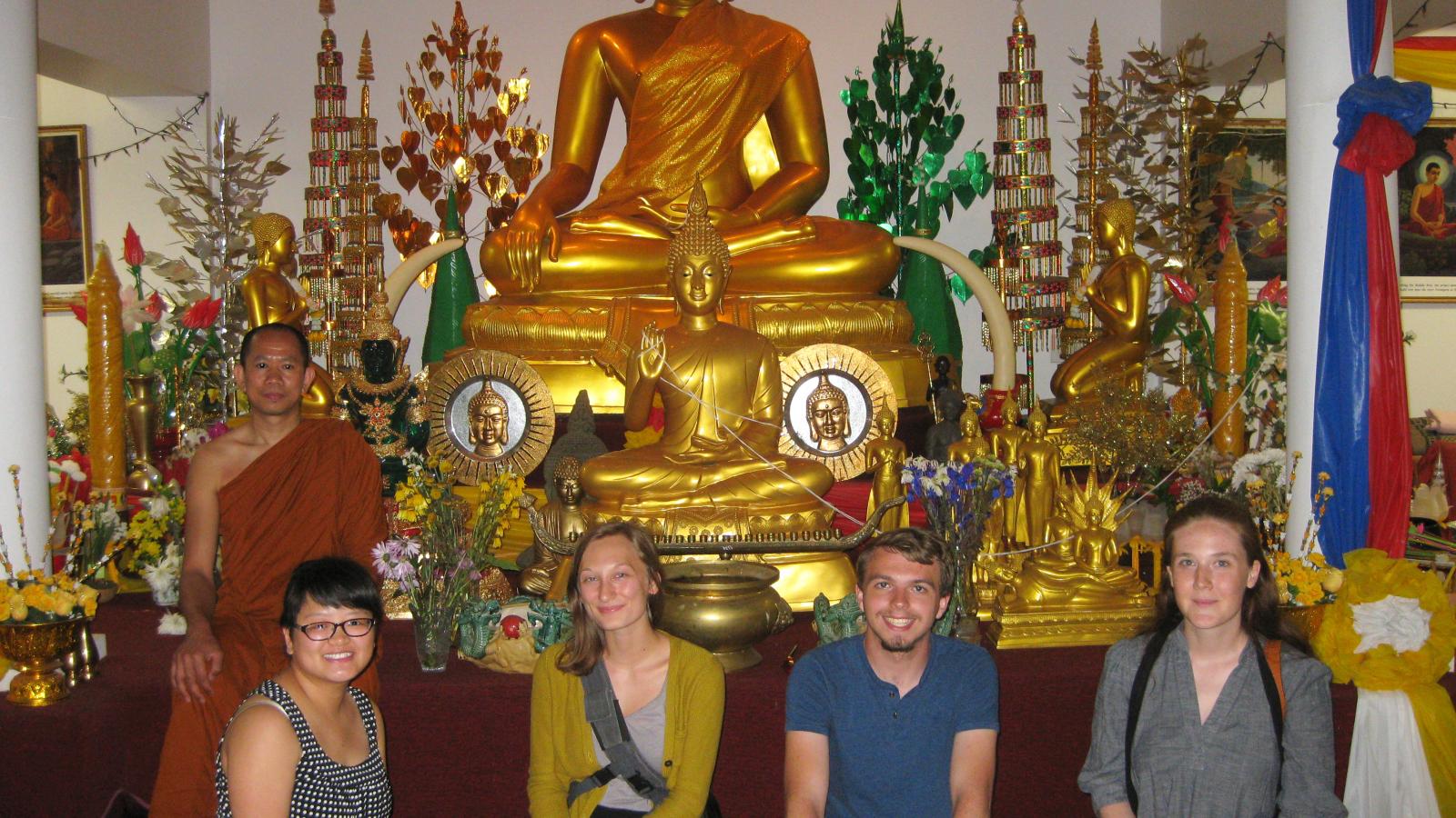 Field research students Dan, Ada, Austin and Kati pictured with Wat Buddhasamakidham Theravada monk Ajanh Sun inside the barn temple. 