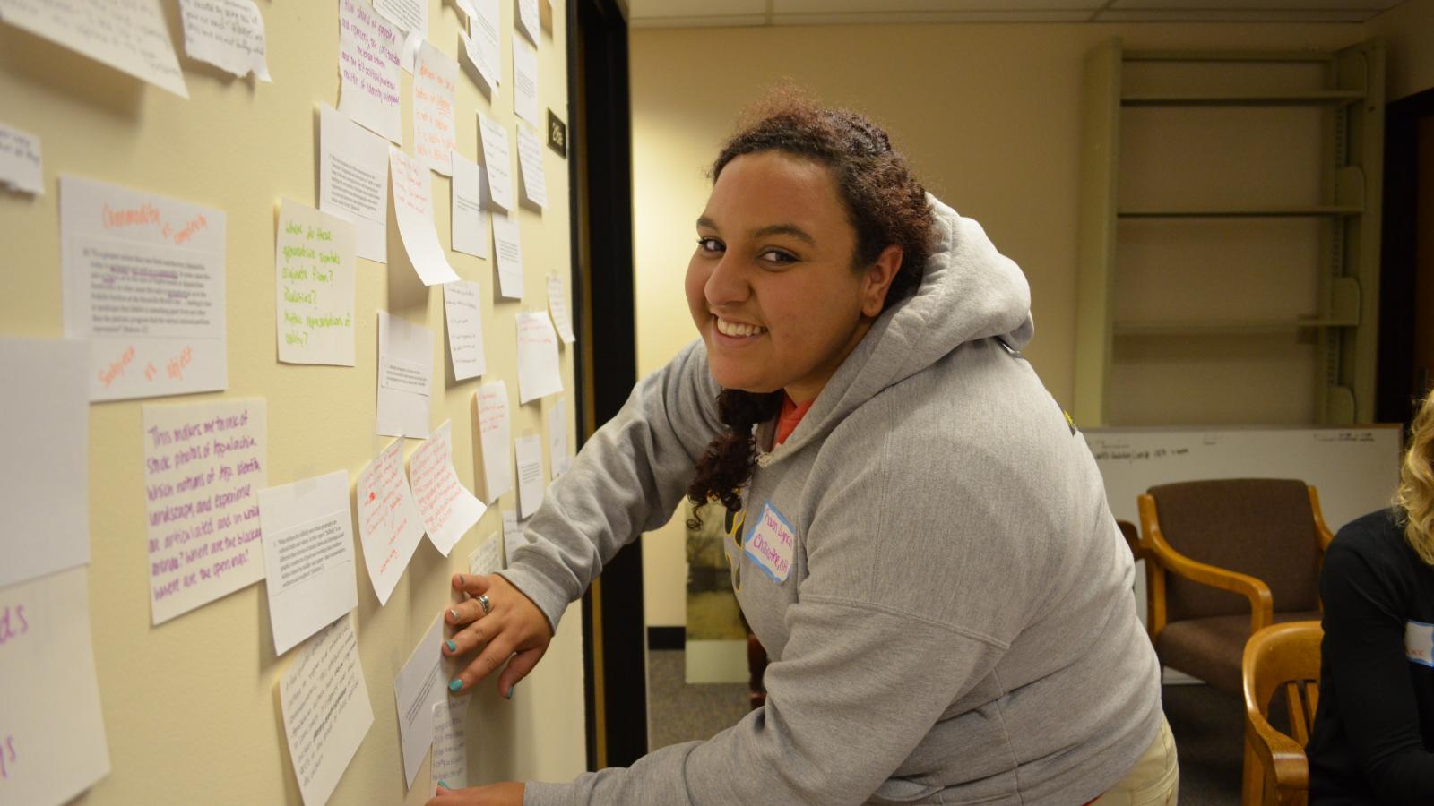Raven Lynch posts on the brainstorm board at the 2013 retreat