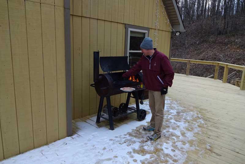 Reece Brown standing by grill outside his home