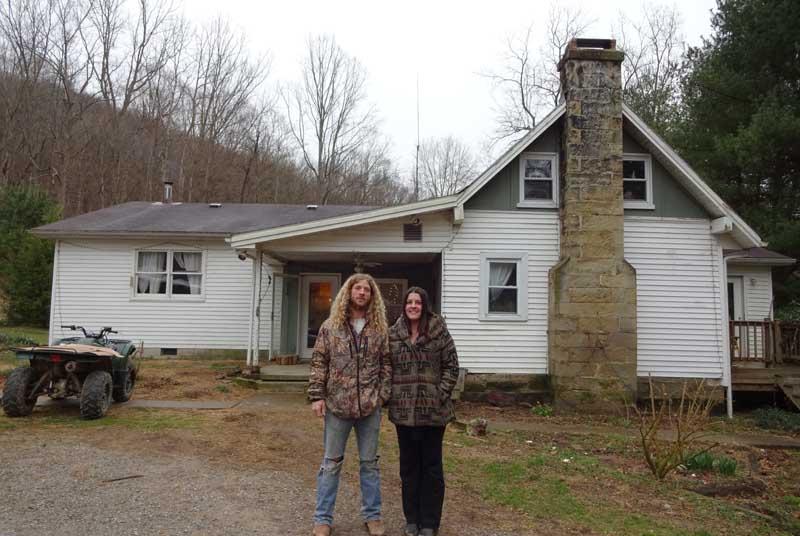 Emily Harper and Justin Carman in front of their home