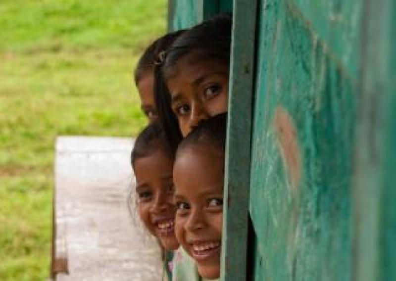 Kids in Central America Central American kids leaning out of a window smiling
