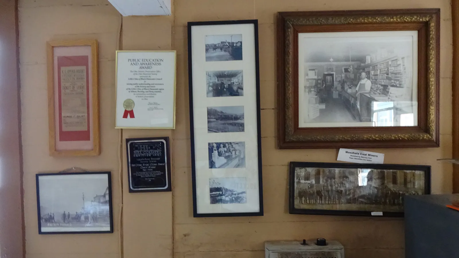 Photos and awards displayed on the wall of the Little Cities of Black Diamonds Council Office