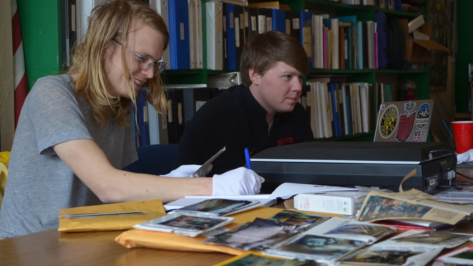 Austin Miles (left) and Burton Bassett (right) digitizing archival photos at Monday Creek Restoration Project’s office