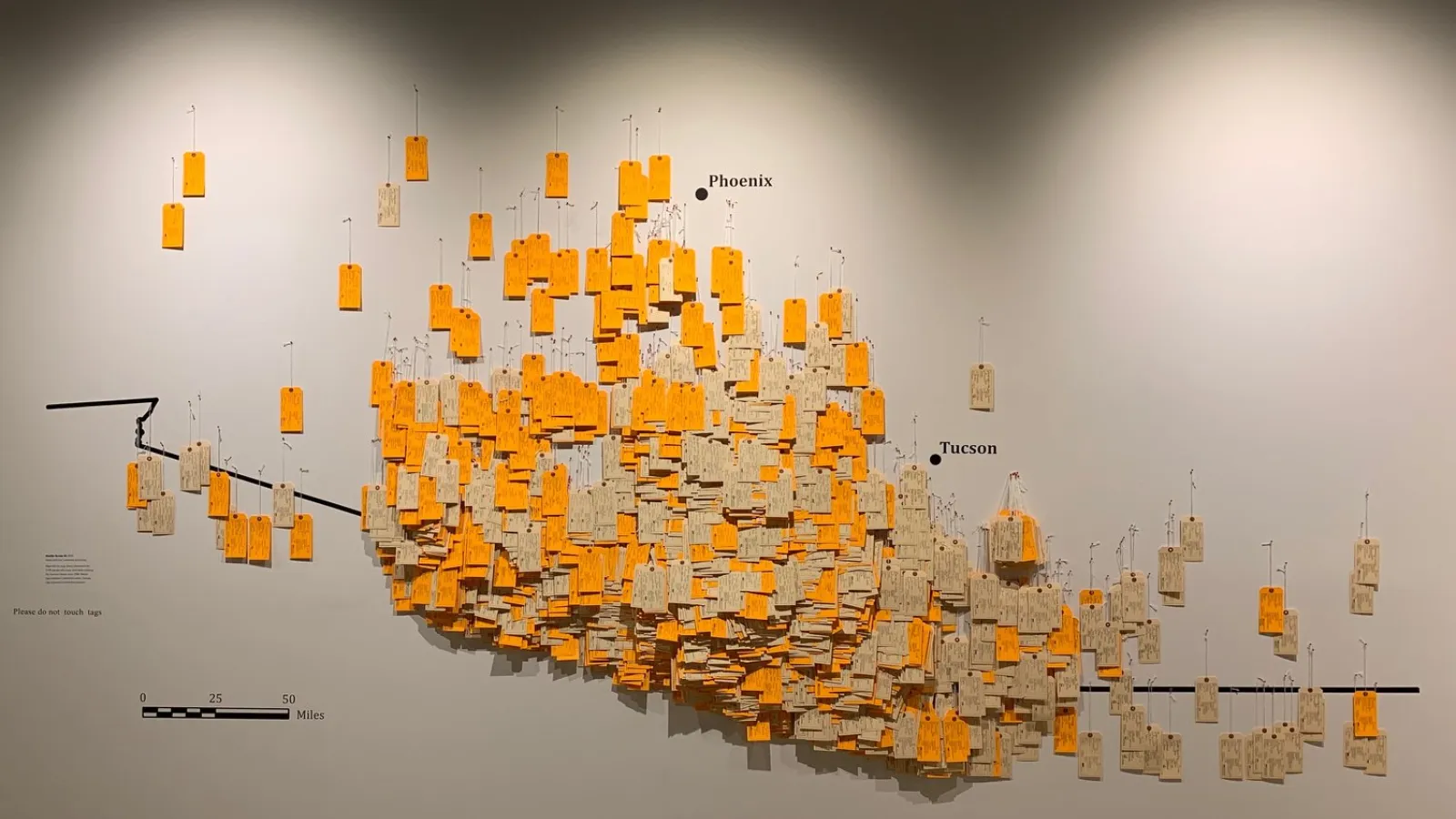 border to columbus - toe tags hung on a wall symbolizing migrant deaths along the border of Arizona