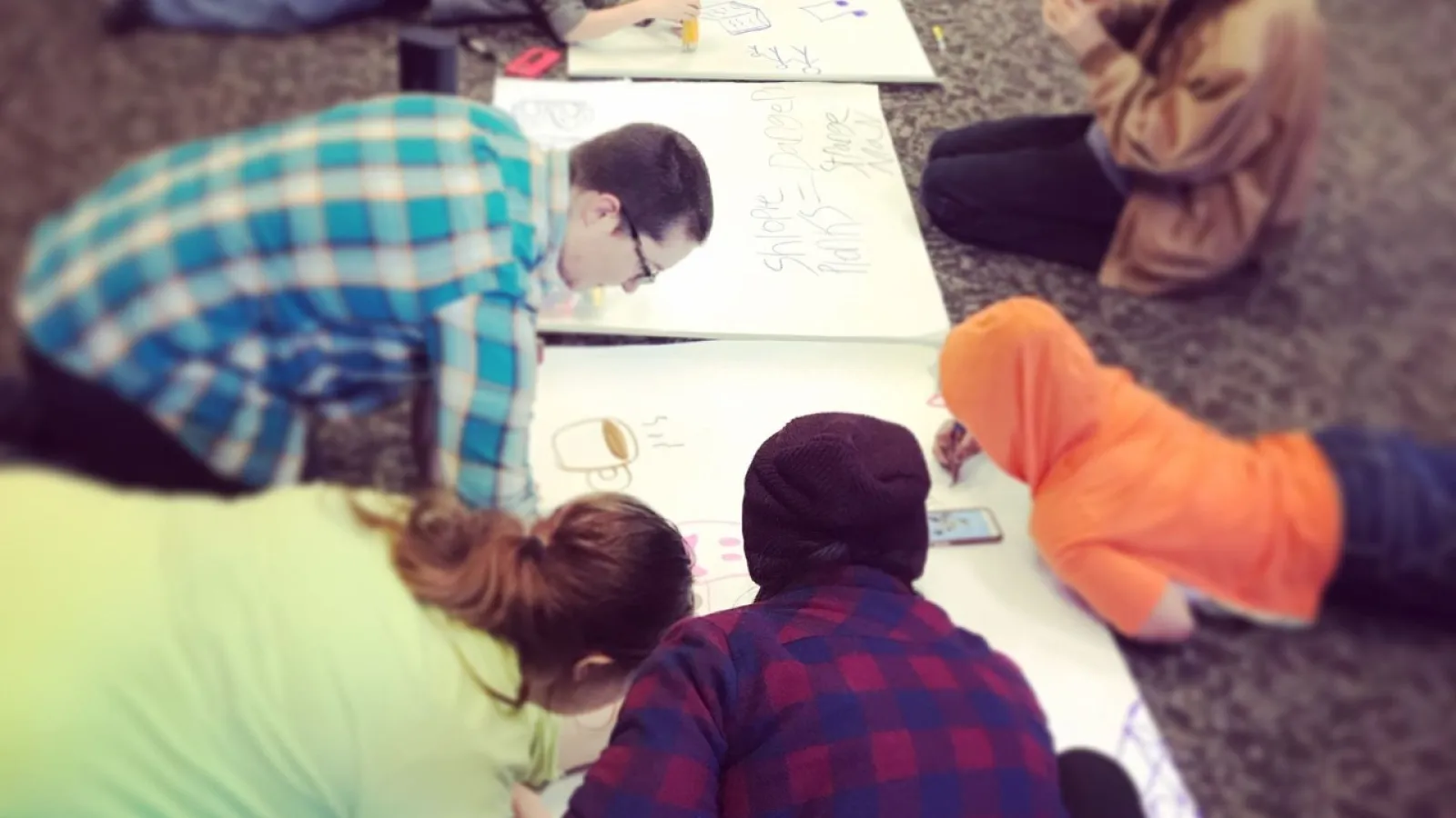 Be The Street participants writing on large pads of white paper