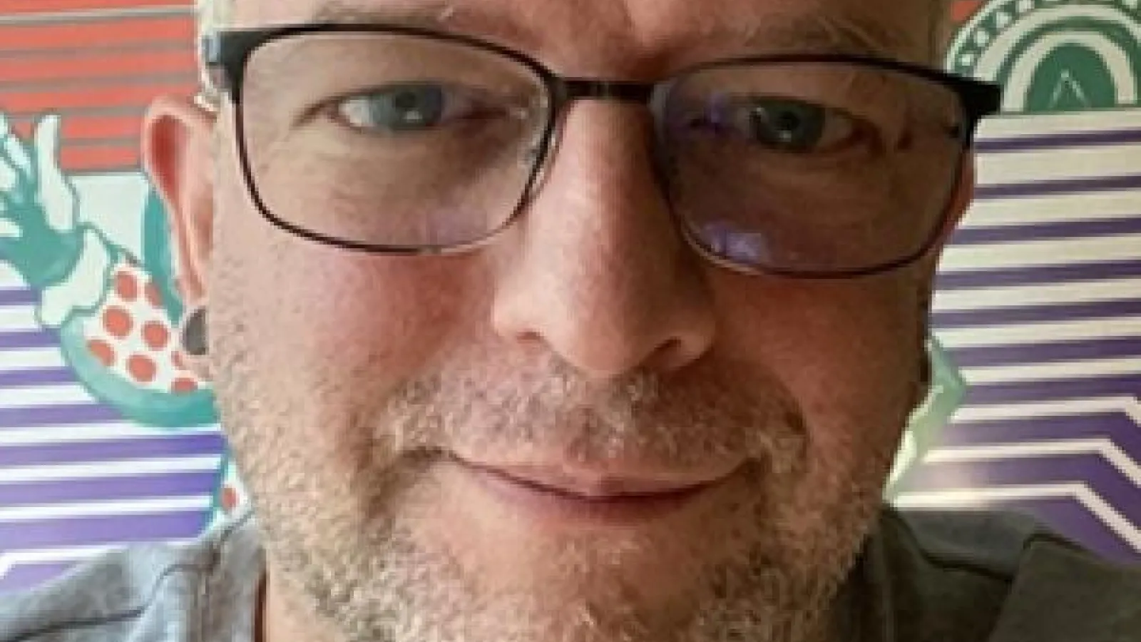 Close-up headshot of Jared Gardener, who is a white male smiling and wearing glasses