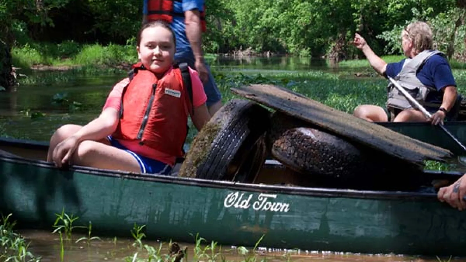 young volunteer with Friends of Scioto Brush Creek canoe with trash extracted from Creek