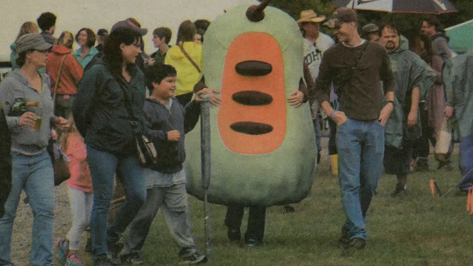 Image from a January 25, 2016 article about the Pawpaw Festival. The infamous pawpaw costume walks amongst festival-goers.