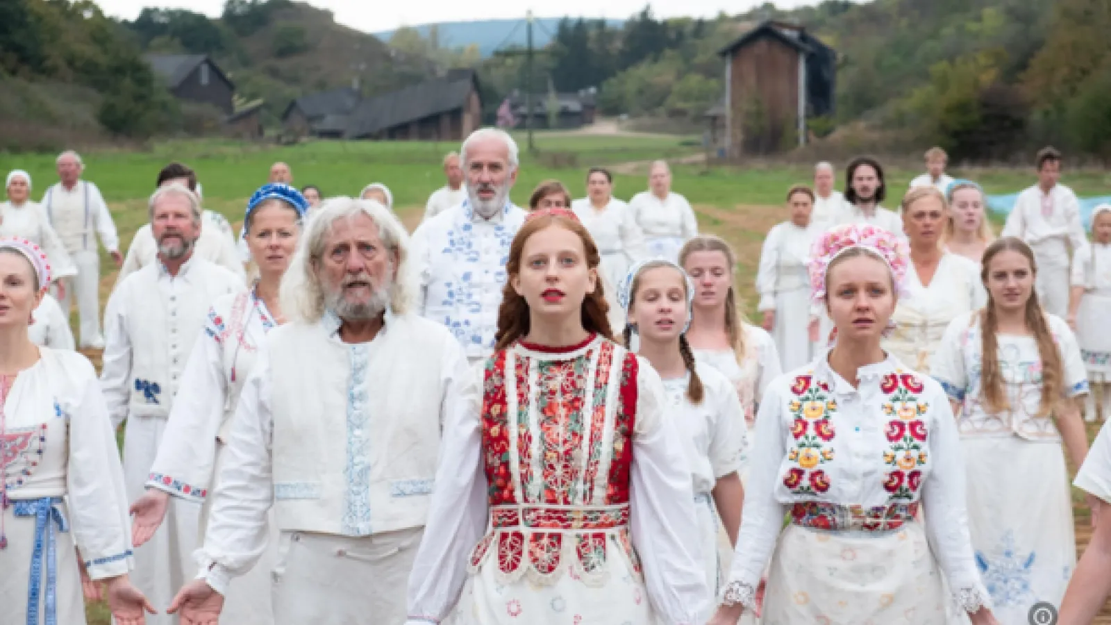 a group of people in traditional floral dress standing in a field