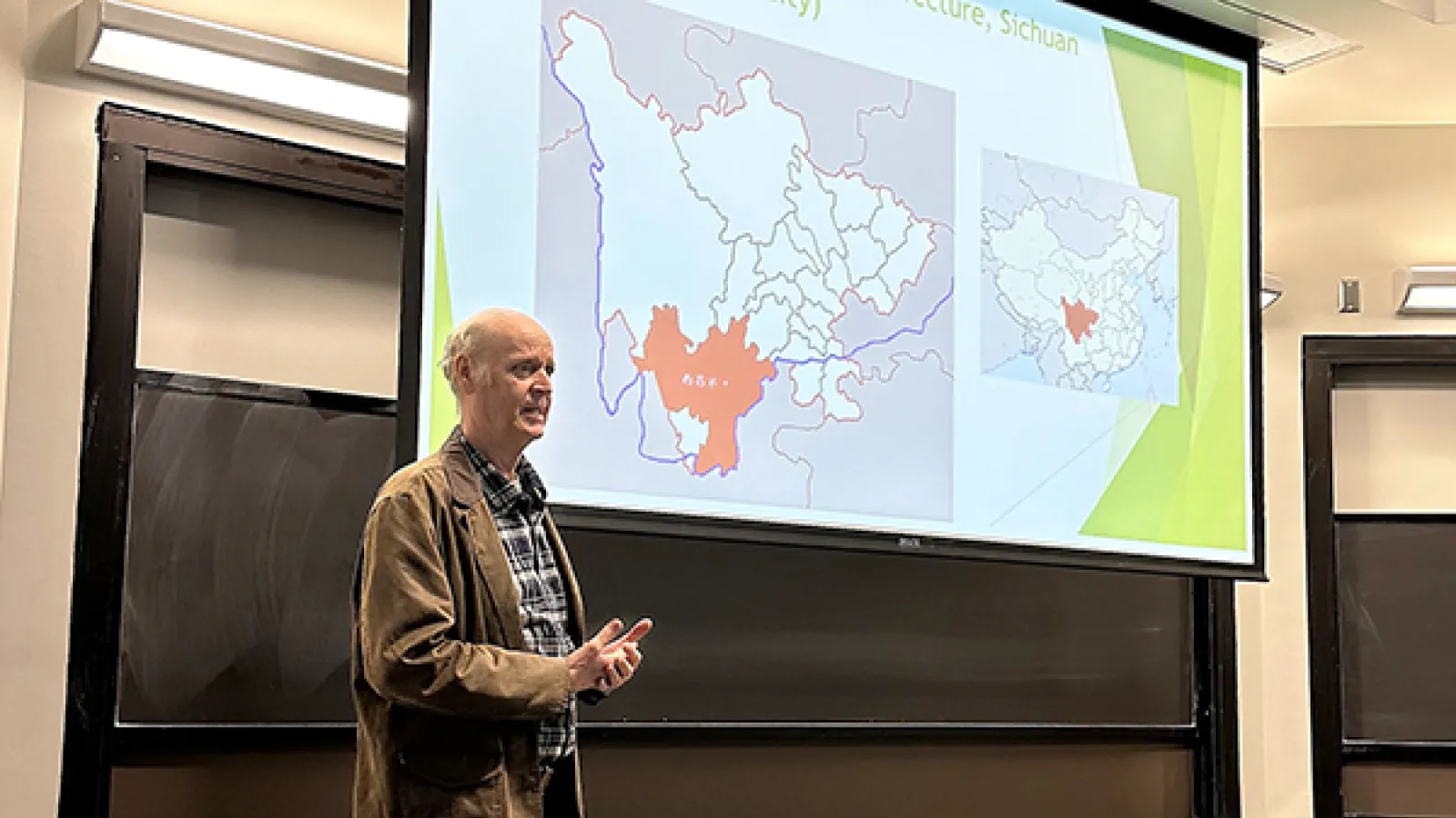 Dr. Mark Bender stands in front of a slide showing a region in China