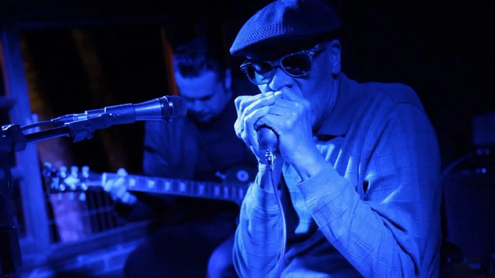 Coleman playing harmonica on stage