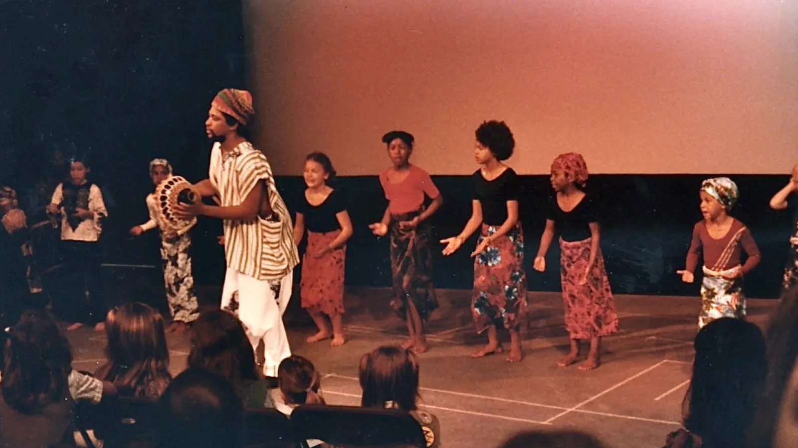 Harris performing on stage with children
