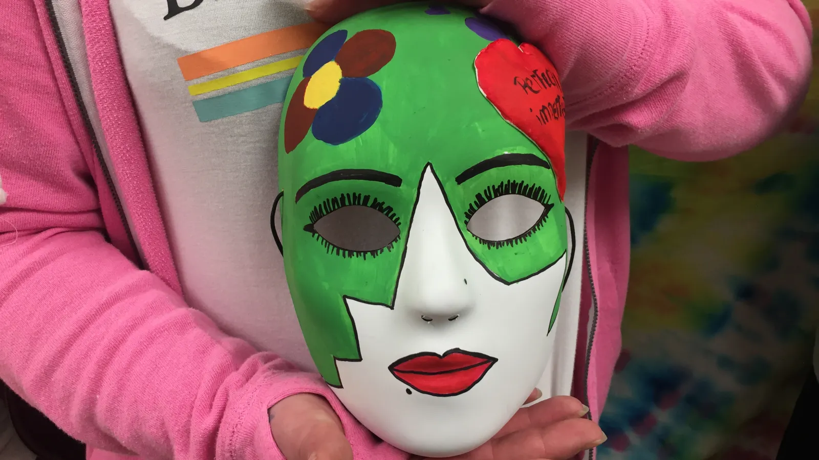 Close-up picture of Fawn's art therapy mask as she holds it.