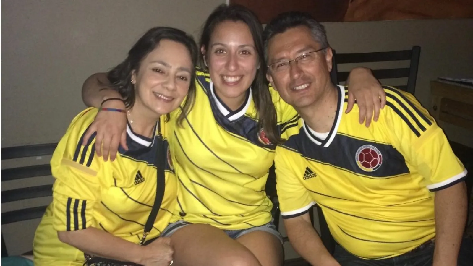 Laura and her parents wearing Colombian jerseys 