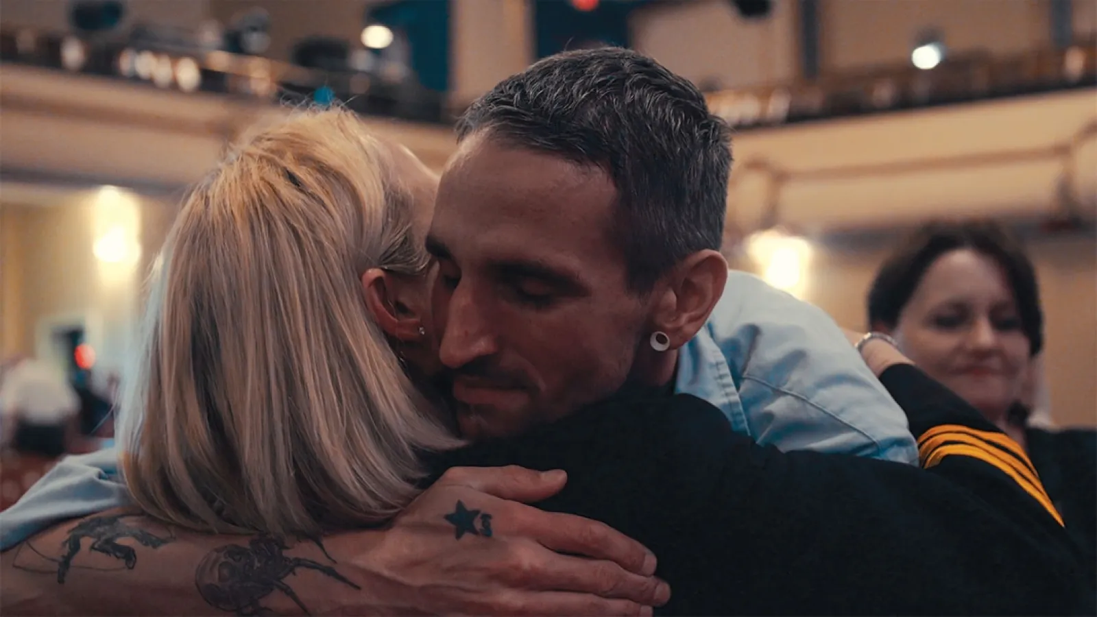 Jan Radner hugging man she works with