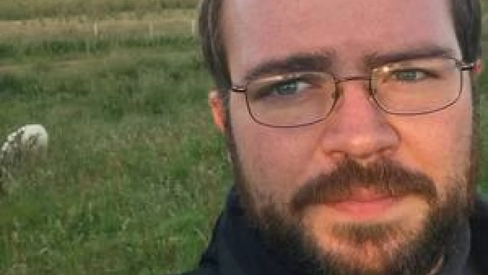 Christopher Johnson standing in a field.