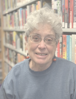 Photo of Margaret Mills in front of bookshelf