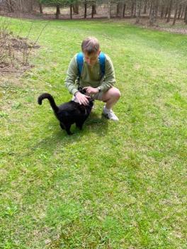 A woman kneels with a cat