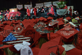 Various red graduation mortarboards at graduation