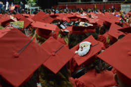 Various red graduation mortarboards at graduation