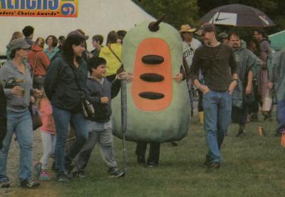 Image from a January 25, 2016 article about the Pawpaw Festival. The infamous pawpaw costume walks amongst festival-goers.
