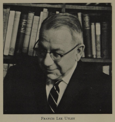 Francis Lee Utley - a man in glasses in front of a display of books