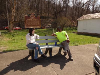 A woman and a man sit on a bench