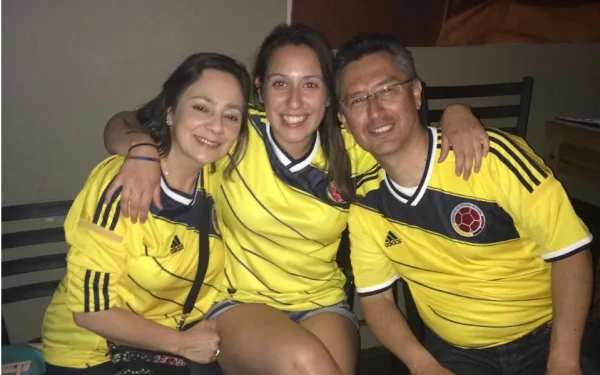 Laura and her parents wearing Colombian jerseys 