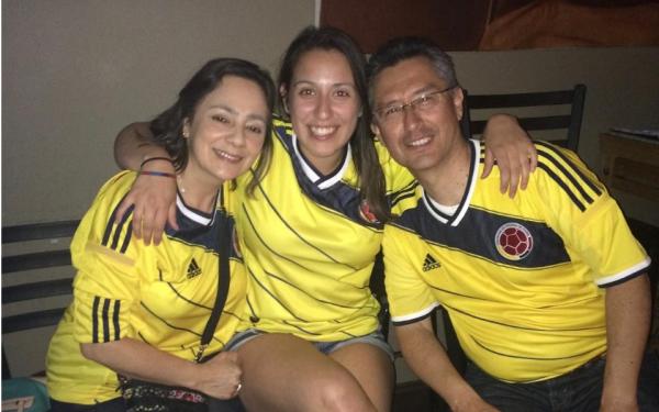 Laura and her parents wearing Colombian jerseys 