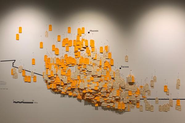 border to columbus - toe tags hung on a wall symbolizing migrant deaths along the border of Arizona