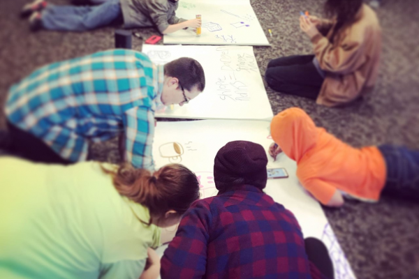 Be The Street participants writing on large pads of white paper