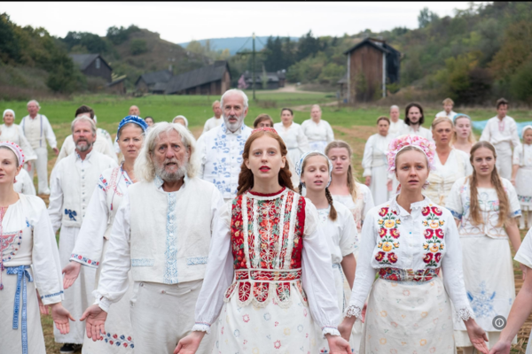 a group of people in traditional floral dress standing in a field