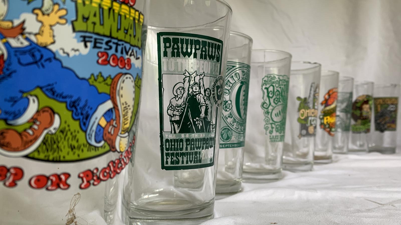 A line of pint glasses with assorted logos