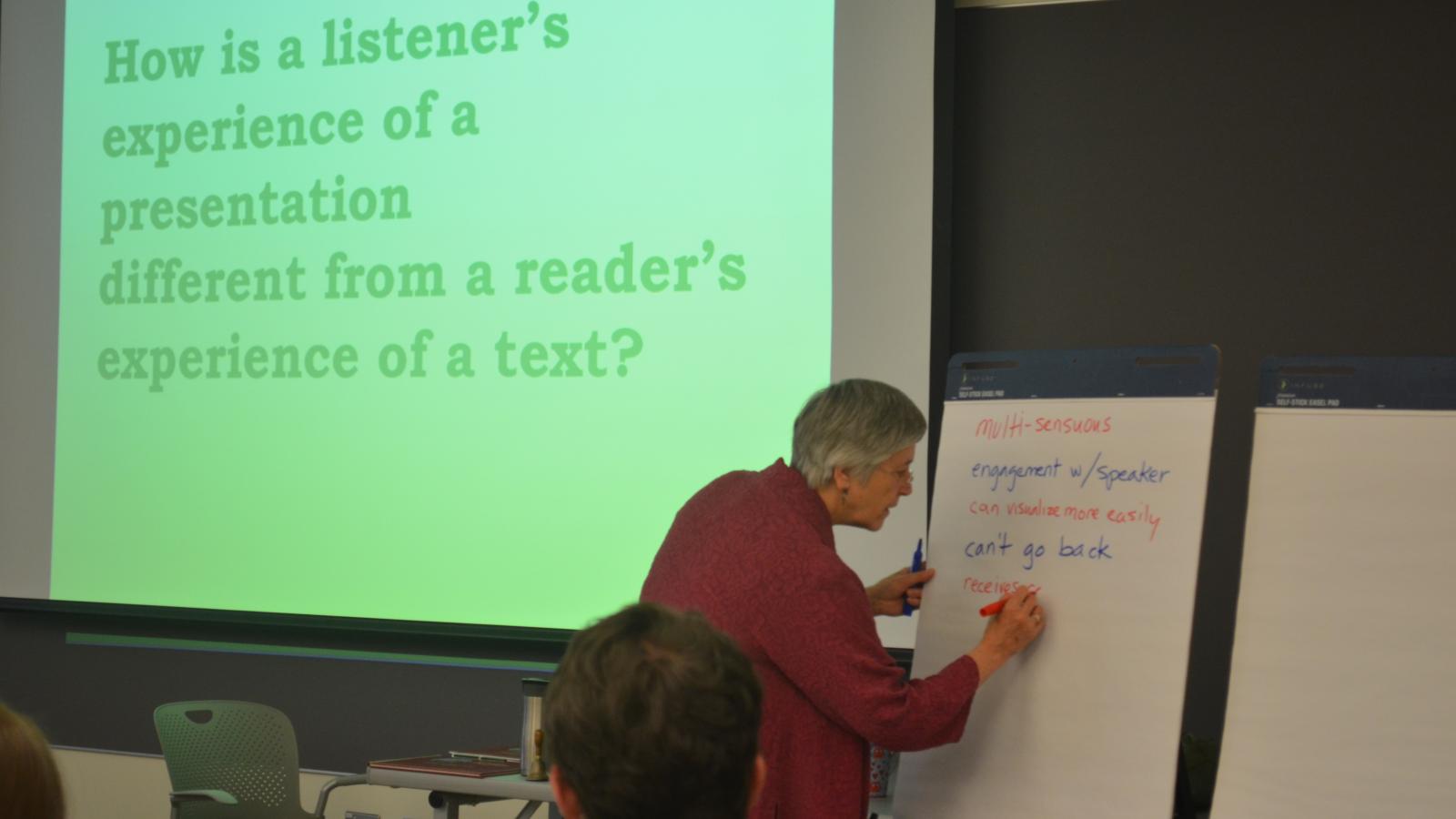 Jo Radner writing notes for the Interviewing for Story Workshop