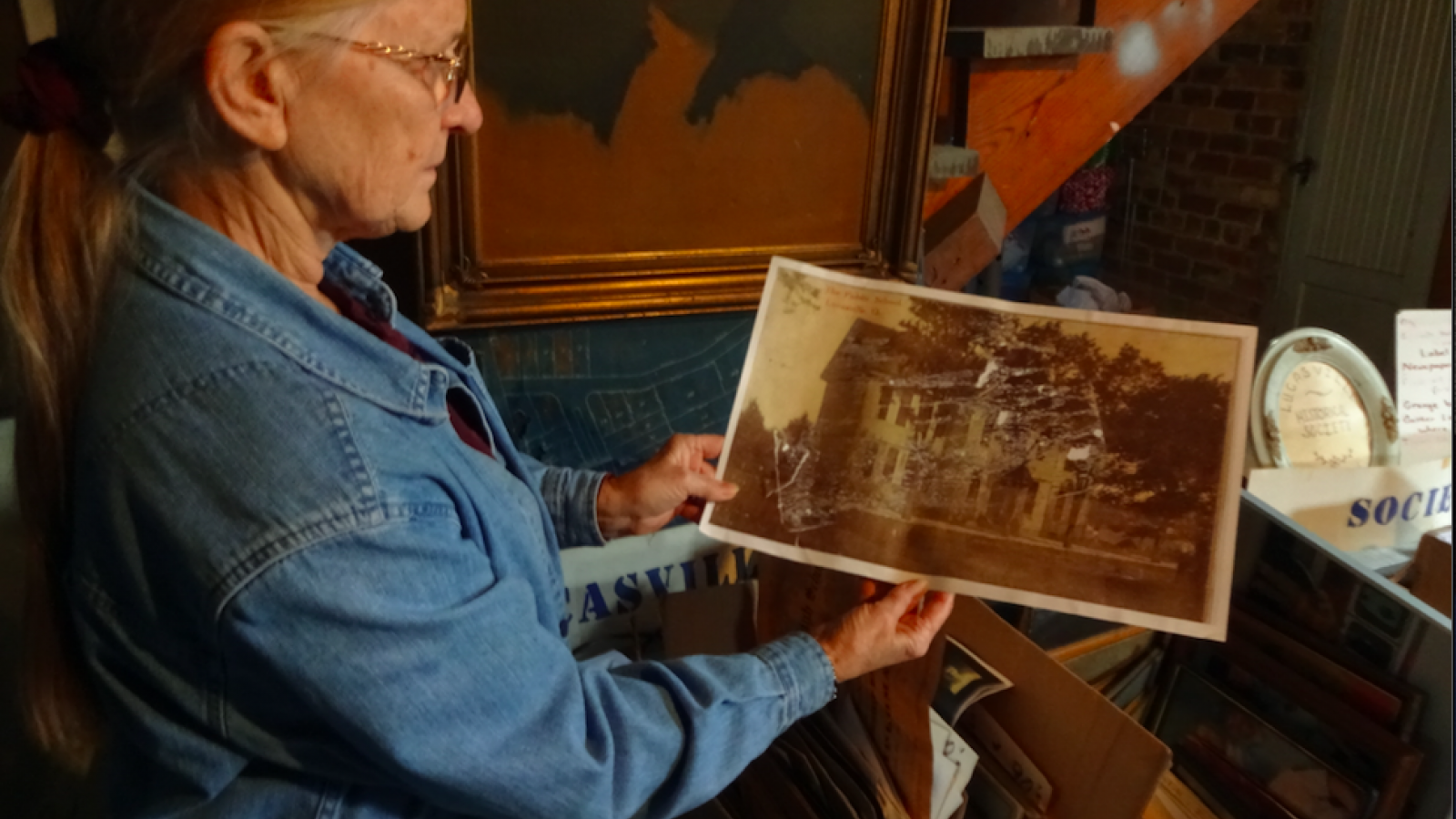 Pat Smith holding up an old image of the Emmanuel United Methodist Church.