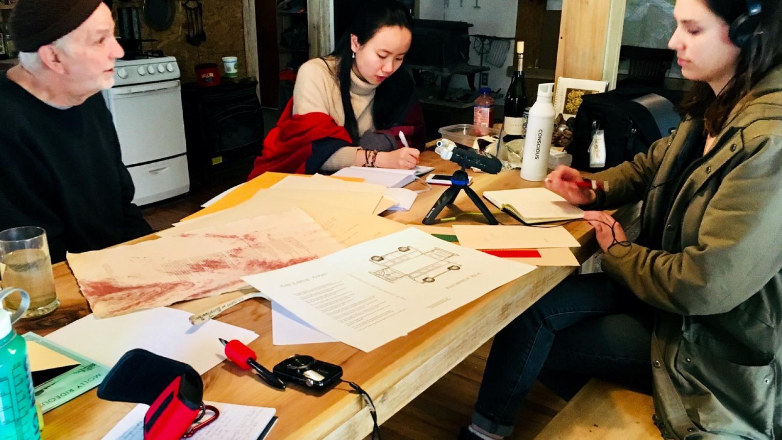 Brian Richards (left) discussing the process of print pressing with Ana Mitchell and Luna Luo.